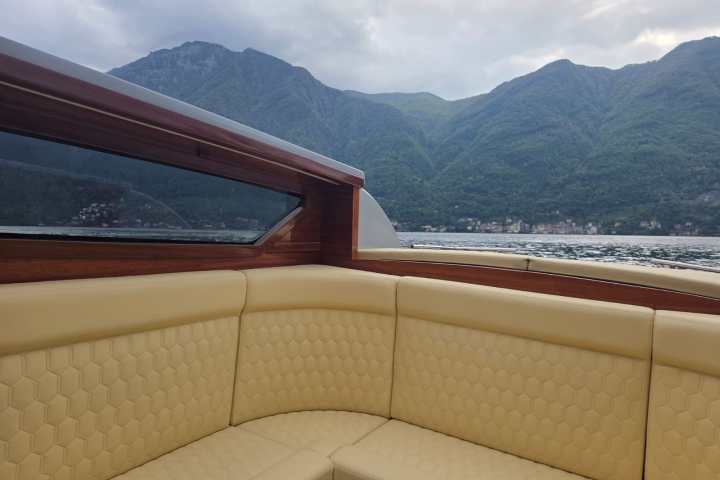 Boat interior with tan seating and mountain view.
