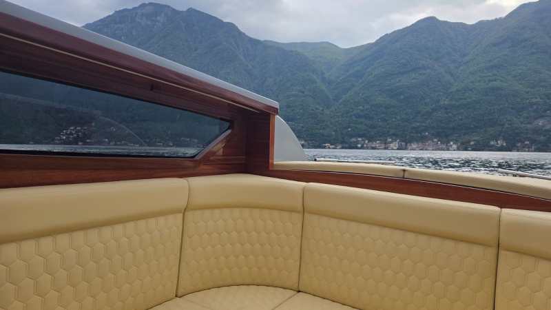 Boat interior with tan seating and mountain view.